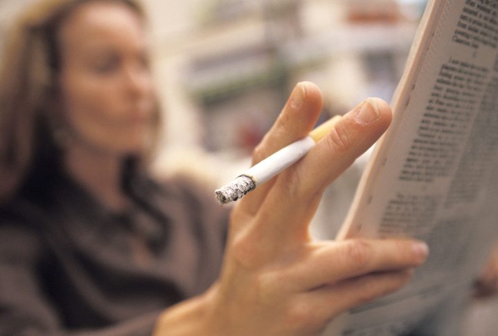 Woman Smoking and Reading the Paper