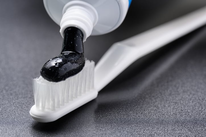 Black charcoal whitening toothpaste being squeezed from tube